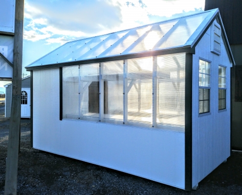 white greenhouse from side view, showcasing glass walls and ceiling