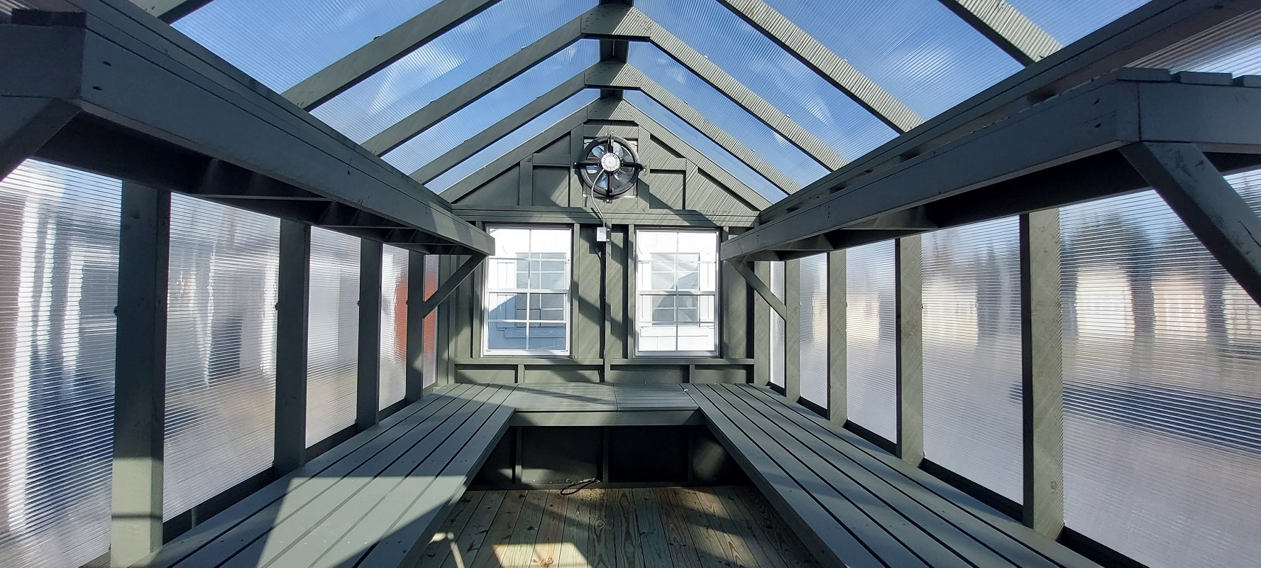 Interior of blue greenhouse, showcasing ceiling, windows and ventilation