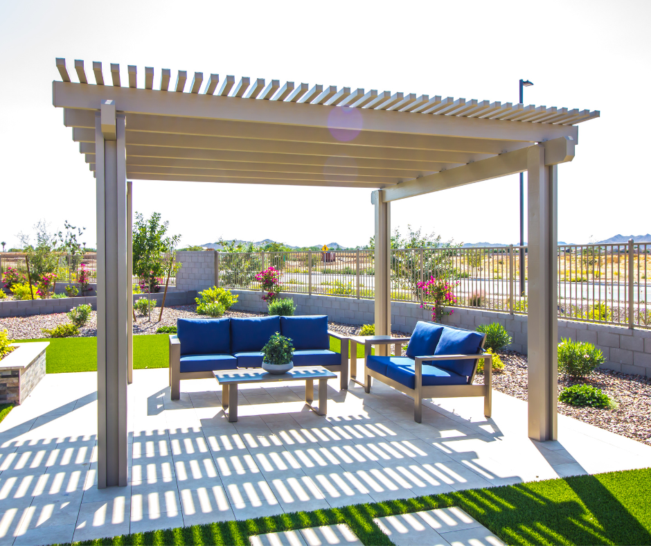pergola in backyard with blue outdoor chairs underneath.