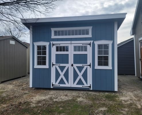 Shed with blue siding, white trim and 3 windows