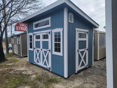Shed with blue siding, white trim, 3 windows and 3 doors
