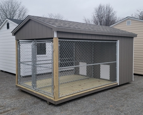 Dog kennel with two dog boxes and two dog runs with tan siding.